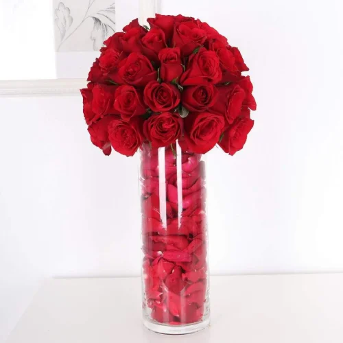 Indulge in the classic elegance of our Elegant Red Rose Tower Vase, featuring a lush bouquet of vibrant red roses beautifully arranged in a tall glass vase filled with delicate rose petals. This luxurious arrangement radiates romance and sophistication, making it the perfect gift for anniversaries, Valentine’s Day, or any special occasion. The towering vase adds a modern touch, bringing a sense of grandeur to any space and showcasing the beauty of each rose. This arrangement is a timeless expression of love and appreciation. Care Instructions: Place in a cool, shaded area, away from direct sunlight and heat. Add a little water to the vase every two days to keep the flowers fresh. Avoid placing near air conditioners or heaters.